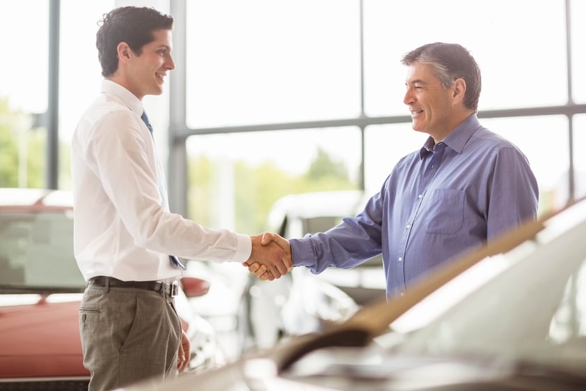 Dealer shaking hands with customer.