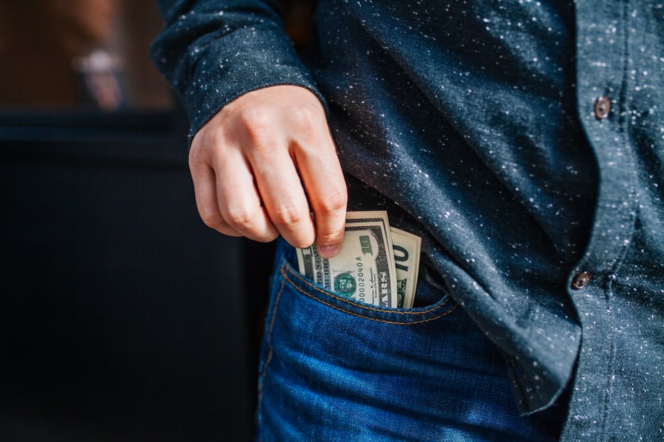 Person putting money in pocket 